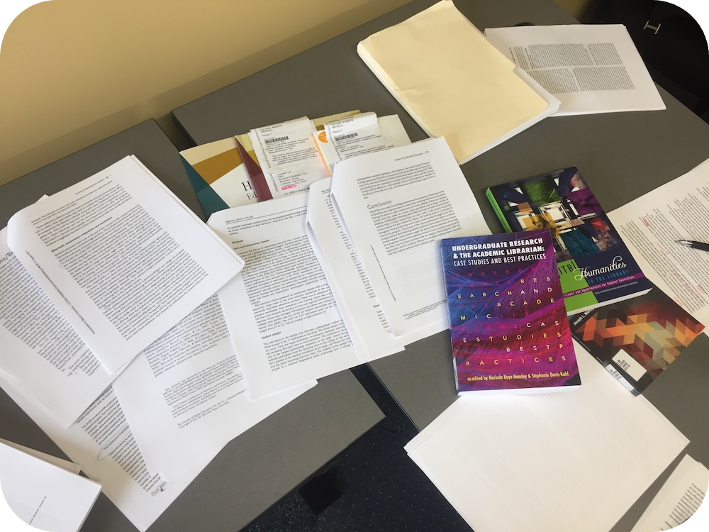 a pile of books and articles on a desk